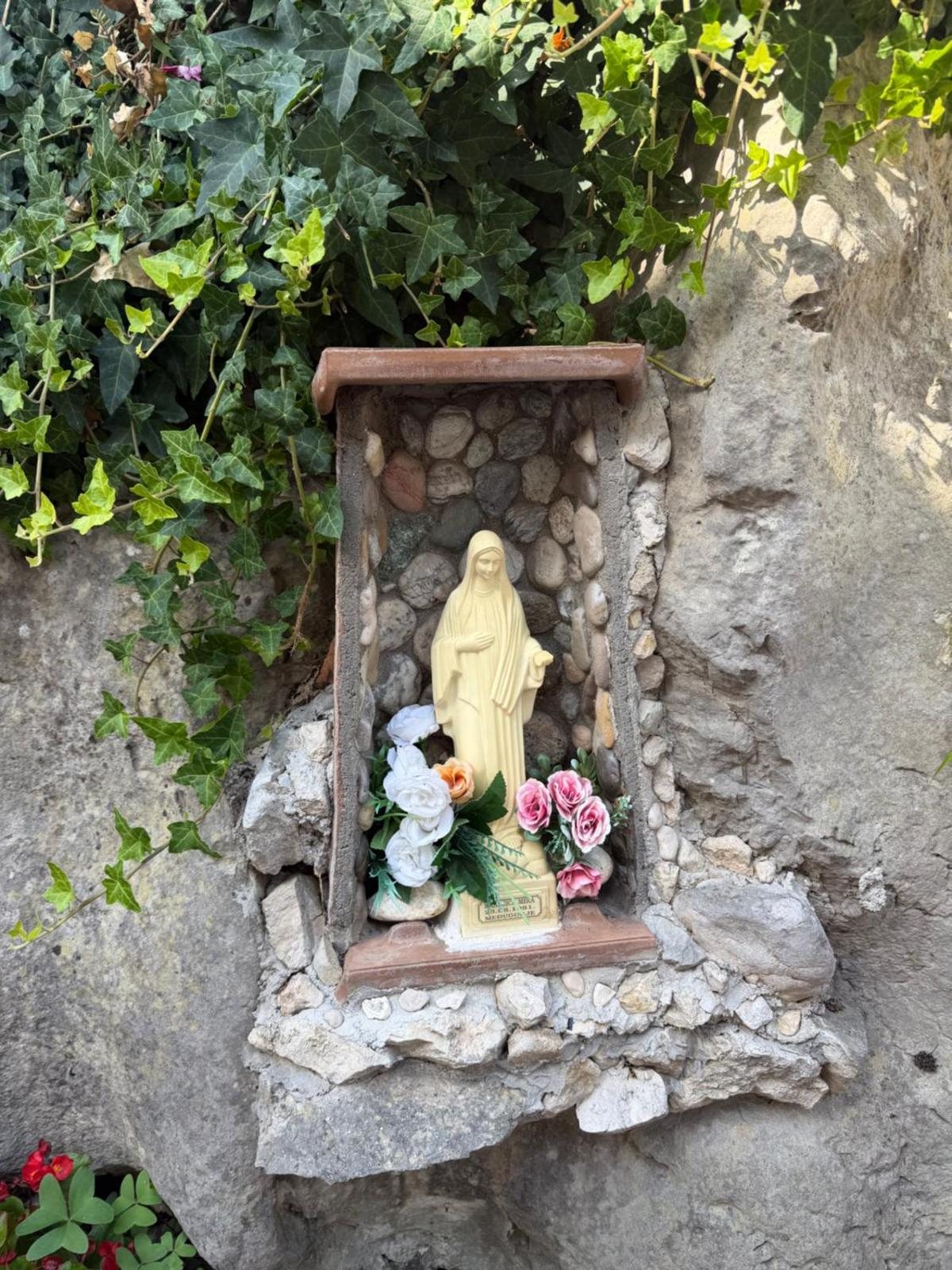 Edicola votiva in pietra lungo un muro del borgo