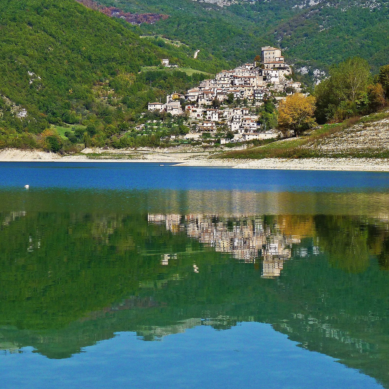Il borgo di Castel di Tora riflesso nelle acque verdi del lago
